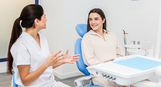 Dentist in white scrubs discussing things with patient
