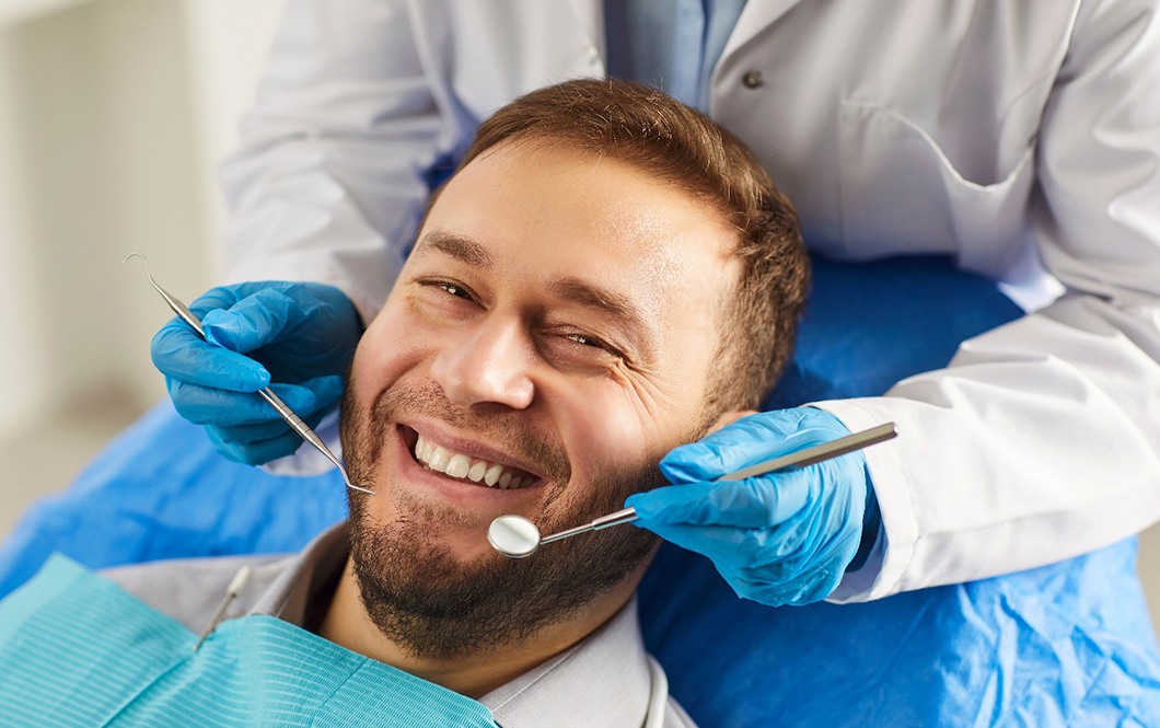 A man getting his teeth examined by a dentist