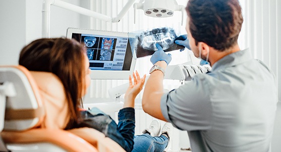 A dentist showing a patient an X-ray
