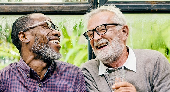 Implant dentures patient in Lakewood smiling with friend
