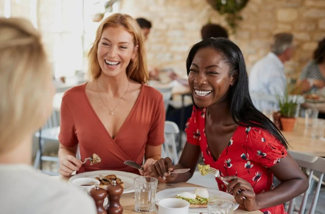Two women laughing at a table in a restaurant