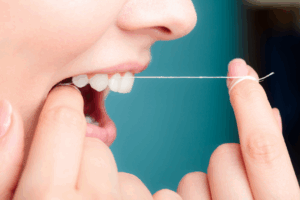 a patient carefully flossing their teeth